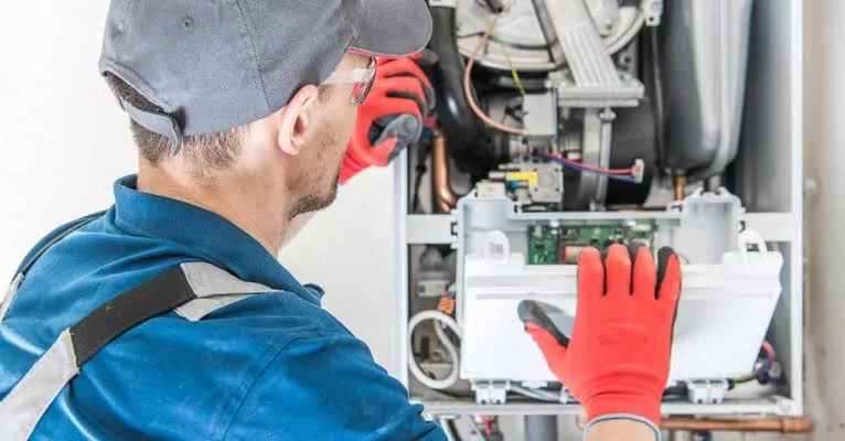 Technician inspecting the controls inside a residential heating system