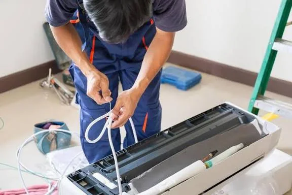 Technician servicing the control area of a wall-mounted cooling system