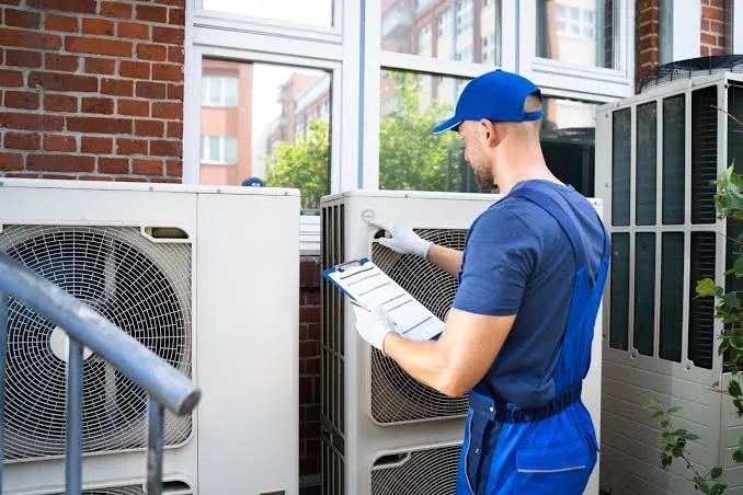 HVAC technician checking outdoor cooling equipment during a residential service visit